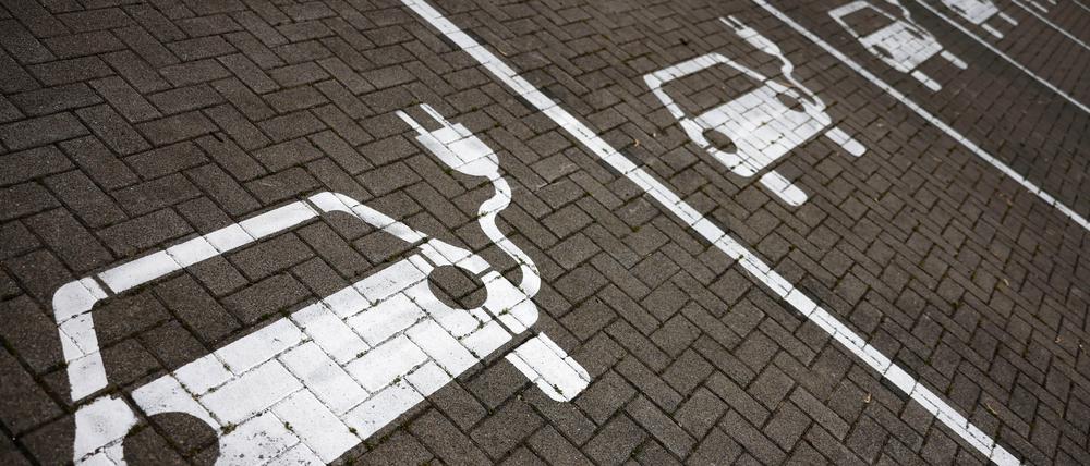 Piktogramme mit Autos, aus denen ein Stromkabel ragt, markieren Parkplätze mit Ladesäulen, an denen Elektro-Autos ihren Akku laden können. 