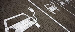 Piktogramme mit Autos, aus denen ein Stromkabel ragt, markieren Parkplätze mit Ladesäulen, an denen Elektro-Autos ihren Akku laden können.