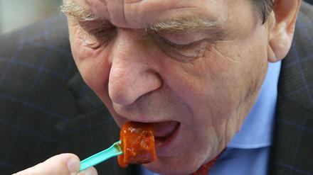 Der ehemalige Bundeskanzler Gerhard Schröder isst in einer Steglitzer Kleingartenanlage Currywurst. Es ärgerte ihn, als vor zwei Jahren die berühmte VW-Currywurst in einer der Werkskantinen des Wolfsburger Autobauers abgeschafft wurde. 