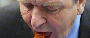 Der ehemalige Bundeskanzler Gerhard Schröder isst in einer Steglitzer Kleingartenanlage Currywurst. Es ärgerte ihn, als vor zwei Jahren die berühmte VW-Currywurst in einer der Werkskantinen des Wolfsburger Autobauers abgeschafft wurde. 