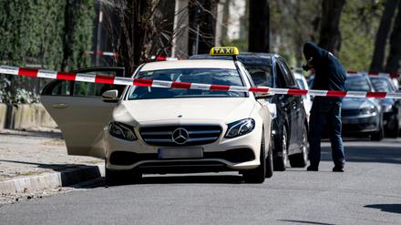 Mitarbeiter der Berliner Polizei steht vor einem Taxi in Berlin-Grunewald. (Archivbild)