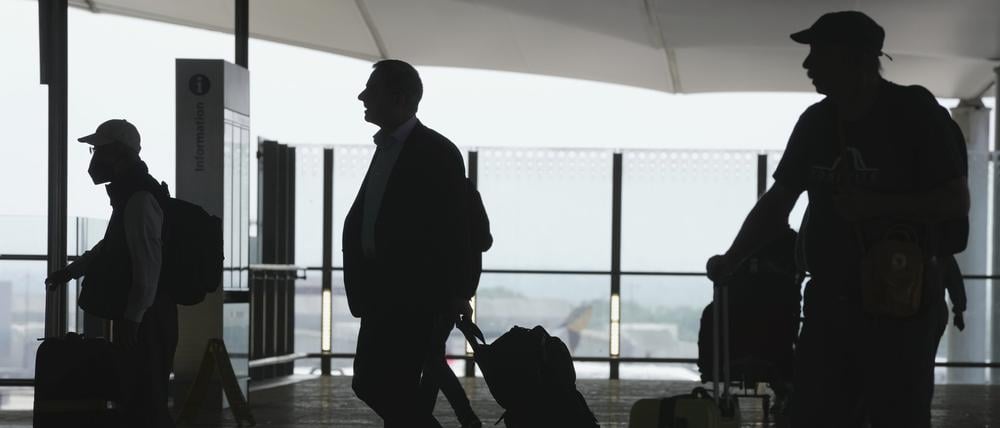 Passagiere gehen mit ihrem Gepäck durch den Flughafen Heathrow in London.