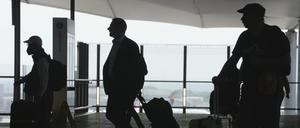 Passagiere gehen mit ihrem Gepäck durch den Flughafen Heathrow in London. 