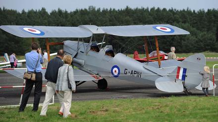 Besucher besichtigen am Samstag (17.09.2011) während des Flugplatzfestes auf dem ehemaligen Flugplatz Berlin-Gatow ein Flugzeug de Havilland D.H.82 Tiger Moth. Anlässlich des Festes sind auf dem Flugplatz seit 17 Jahren erstmals wieder Flugzeuge gestartet und gelandet. Foto: Hannibal dpa/lbn +++(c) dpa - Bildfunk+++
