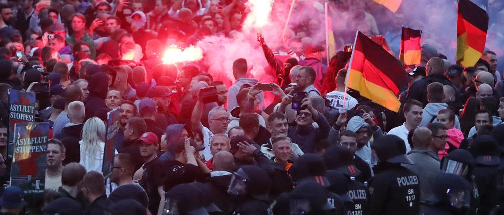 Demonstranten der rechten Szene zünden in Chemnitz Pyrotechnik und schwenken Deutschlandfahnen. 