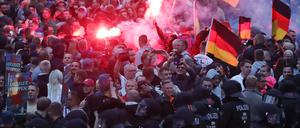 Demonstranten der rechten Szene zünden in Chemnitz Pyrotechnik und schwenken Deutschlandfahnen. 