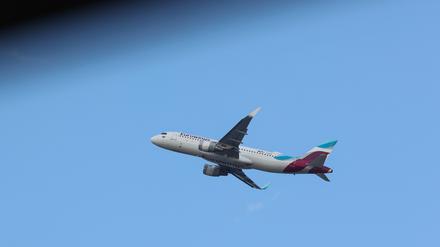 Eine Maschine der Fluggesellschaft Eurowings startet am Hamburger Flughafen vor blauem Himmel. 