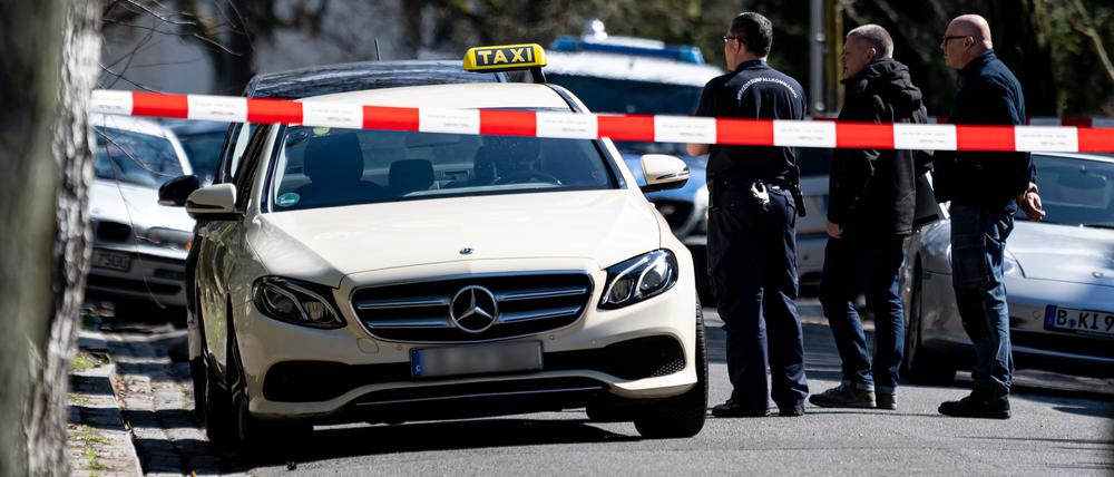 Mitarbeiter der Berliner Polizei steht vor einem Taxi in Berlin-Grunewald. Am Donnerstagmorgen gab in der Brahmsstraße es einen tätlichen Angriff auf den Fahrer des Taxis. +++ dpa-Bildfunk +++