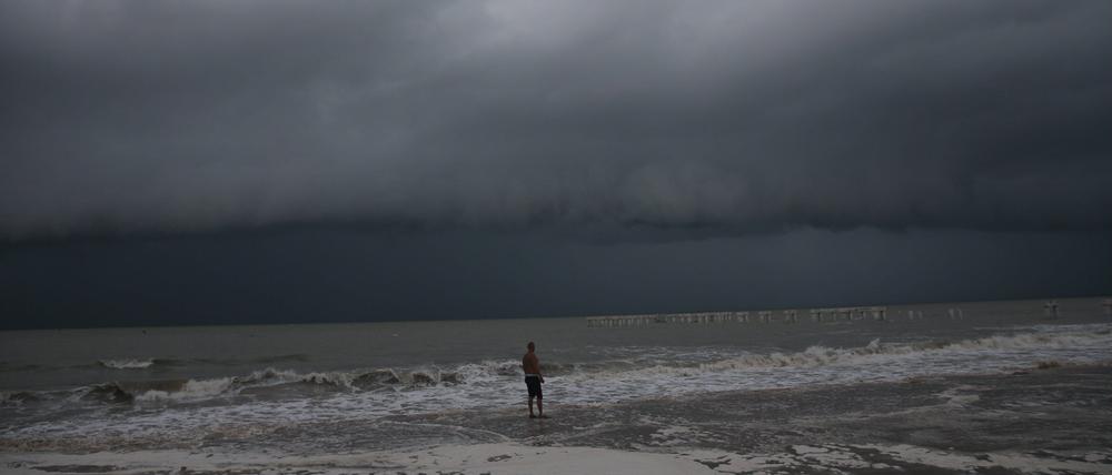 Strandbesucher beobachten die Brandung, während sich Hurrikan Idalia am Dienstag, dem 29. August 2023,am Fort Myers Beach dem Bundesstaat Florida nähert.