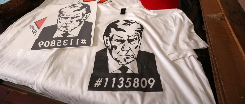T-Dhirts und Kappen mit dem Polizeifoto von Donald Trump.