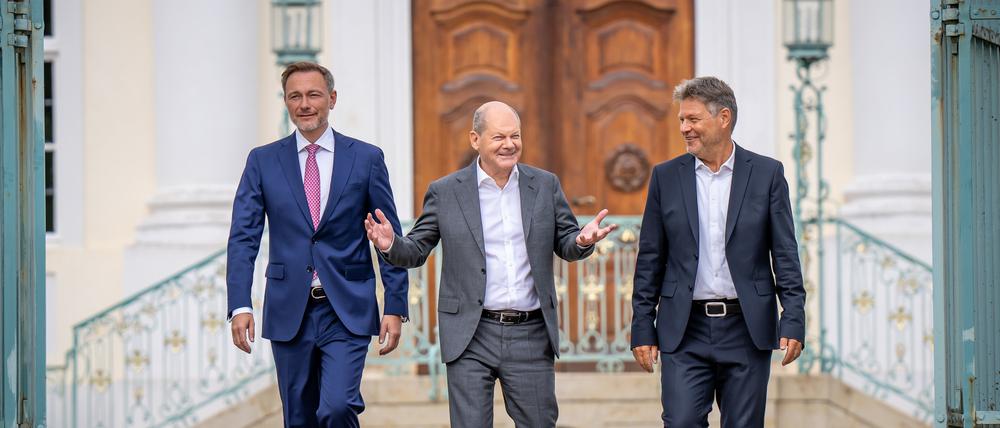 Bundeskanzler Olaf Scholz (SPD, M.), Christian Lindner (FDP, l.), Bundesminister der Finanzen,und Robert Habeck (Bündnis 90/Die Grünen), Bundesminister für Wirtschaft und Klimaschutz, kommen zum Pressesstatement nach der Halbzeitklausur des Bundeskabinetts vor Schloss Meseberg.