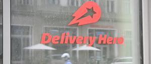 Ein Mopedfahrer spiegelt sich in einer Glasscheibe an der Zentrale des Essenlieferdienstes Delivery Hero. 
