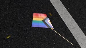 Eine Progressive Pride Flag liegt auf dem Boden. 