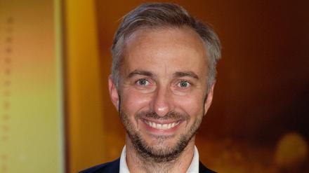 Der Satiriker Jan Böhmermann lacht bei der Verleihung der ersten Fernsehpreise 2022 bei der „Nacht der Kreativen“ (Archivbild).