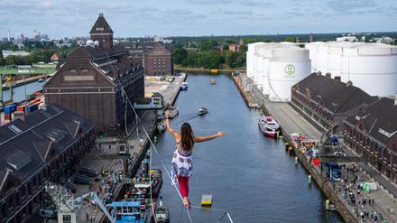 03.09.2023, Berlin: Seil-Akrobatin Kasia balanciert auf einem zwischen zwei Türmen gespannten Hochseil auf beim Fest zum 100-jährigen Bestehen des Berliner Westhafens BEHALA. Foto: Monika Skolimowska/dpa +++ dpa-Bildfunk +++