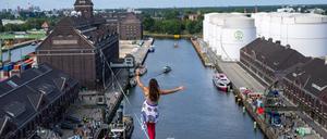 03.09.2023, Berlin: Seil-Akrobatin Kasia balanciert auf einem zwischen zwei Türmen gespannten Hochseil auf beim Fest zum 100-jährigen Bestehen des Berliner Westhafens BEHALA. Foto: Monika Skolimowska/dpa +++ dpa-Bildfunk +++