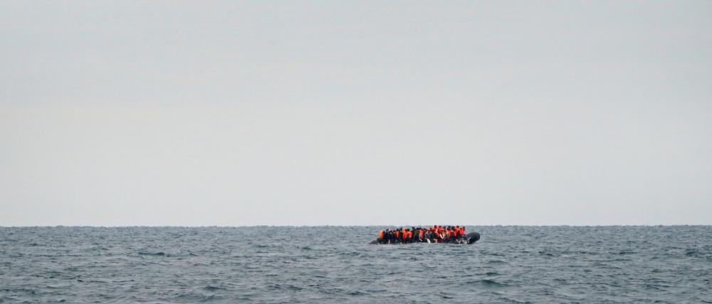Eine Gruppe von Menschen, bei denen es sich vermutlich um Migranten handelt, überquert den Ärmelkanal in einem kleinen Boot, das von der französischen Küste in Richtung Dover fährt.