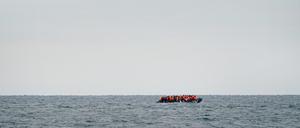 Eine Gruppe von Menschen, bei denen es sich vermutlich um Migranten handelt, überquert den Ärmelkanal in einem kleinen Boot, das von der französischen Küste in Richtung Dover fährt.
