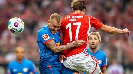 David Raum von RB Leipzig springt zum Kopfball gegen Berlins Kevin Behrens (r).