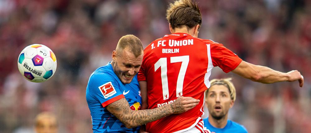 David Raum von RB Leipzig springt zum Kopfball gegen Berlins Kevin Behrens (r).