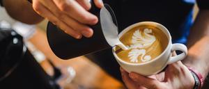 ARCHIV - 03.03.2016, Bayern, Rottendorf: Ein Barrista "malt" mit Milch einen gespiegelten Schwan in einen Cappuccino. In Bremen findet am 27.02.2018 das Finale der deutschen Kaffeemeisterschaften statt. (zu dpa vom 26.02.2018) Foto: Nicolas Armer/dpa +++ dpa-Bildfunk +++