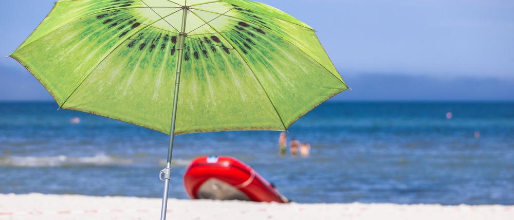 ARCHIV - 15.07.2021, Mecklenburg-Vorpommern, Prerow: Ein großer Sonnenschirm steht am Strand an der Ostseeküste. Fast jeder Vierte in Deutschland hat laut einer Umfrage aus finanziellen Gründen größere Einsparungen beim Urlaub gemacht. In einer repräsentativen Erhebung des IFAK Instituts im Auftrag des privaten rheinland-pfälzischen Radiosenders RPR1 gab zwar fast die Hälfte der Befragten (48 Prozent) an, keine bis fast keine Abstriche beim Sommerurlaub gemacht zu haben. (zu dpa: «Umfrage: Jeder Vierte spart beim Urlaub») Foto: Jens Büttner/dpa-Zentralbild/dpa +++ dpa-Bildfunk +++