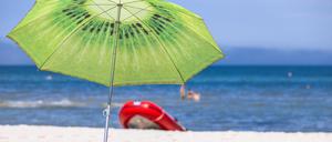 ARCHIV - 15.07.2021, Mecklenburg-Vorpommern, Prerow: Ein großer Sonnenschirm steht am Strand an der Ostseeküste. Fast jeder Vierte in Deutschland hat laut einer Umfrage aus finanziellen Gründen größere Einsparungen beim Urlaub gemacht. In einer repräsentativen Erhebung des IFAK Instituts im Auftrag des privaten rheinland-pfälzischen Radiosenders RPR1 gab zwar fast die Hälfte der Befragten (48 Prozent) an, keine bis fast keine Abstriche beim Sommerurlaub gemacht zu haben. (zu dpa: «Umfrage: Jeder Vierte spart beim Urlaub») Foto: Jens Büttner/dpa-Zentralbild/dpa +++ dpa-Bildfunk +++