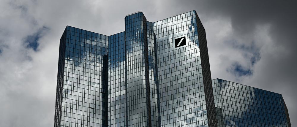 Wolken ziehen über die Zentrale der Deutschen Bank, während sich der Wolkenhimmel in der Fassade spiegelt. 