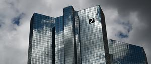 Wolken ziehen über die Zentrale der Deutschen Bank, während sich der Wolkenhimmel in der Fassade spiegelt. 
