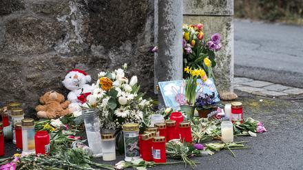 An einer Mauer vor dem Kinder- und Jugendhilfezentrum, in dem eine Zehnjährige tot aufgefunden wurde, liegen Blumen, Kuscheltiere und Kerzen.