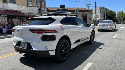 Ein Taxi von der Robotaxi-Firma Waymo  fährt durch die Straße. 