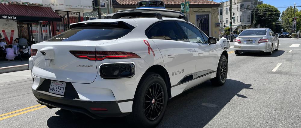 Ein Taxi von der Robotaxi-Firma Waymo  fährt durch die Straße. 