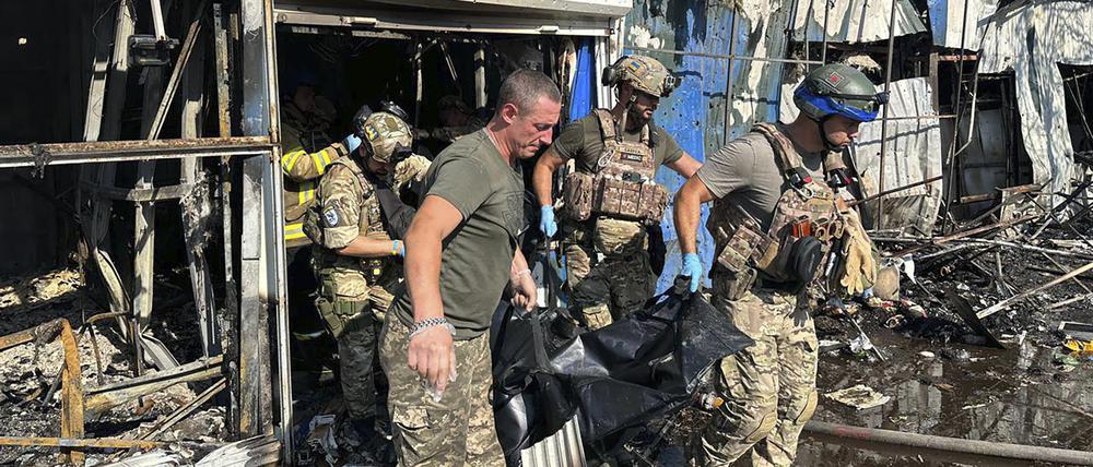 Ukrainische Soldaten und Rettungskräfte tragen am 6. September eine Leiche aus einem Gebäude auf den Marktplatz von Kostjantyniwka.