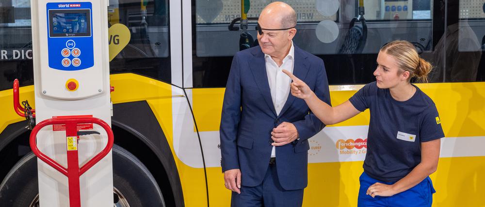 Foto: BVG/Andreas Süß; Auszubildende Emily Nikolay zeigt Olaf Scholz die Kfz-Werkstatt auf dem neuen Ausbildungs-Campus der BVG