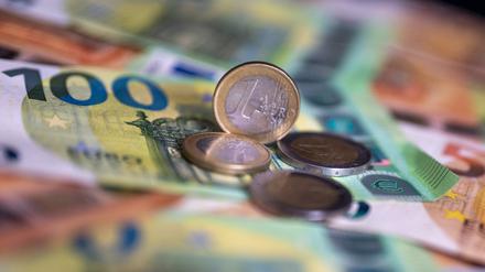 Geldscheine mit dem Wert von 100 und 50 Euro und Münzen liegen auf einem Tisch (Archivbild).