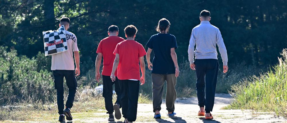 Migranten kommen von der Erstaufnahme-Einrichtungen (EAE) des Landes Brandenburg in Eisenhüttenstadt und gehen durch einen Park.
