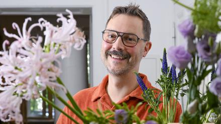 Der Florist Nicolaus Peters steht hinter Blumen, aus denen er einen Blumenstrauß bindet. Er nahm für Deutschland vom 7. bis 9. September am World Cup der Floristinnen und Floristen in Manchester teil.