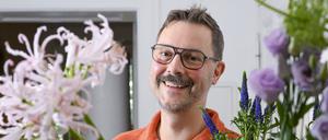 Der Florist Nicolaus Peters steht hinter Blumen, aus denen er einen Blumenstrauß bindet. Er nahm für Deutschland vom 7. bis 9. September am World Cup der Floristinnen und Floristen in Manchester teil.