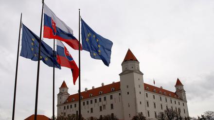 Slowakische und EU-Flaggen vor dem Parlamentsgebäude.