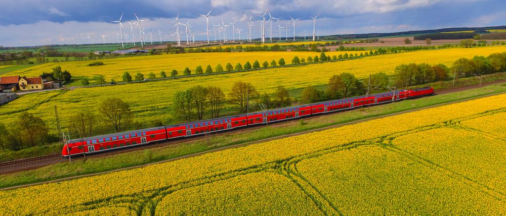 Ein Regionalexpress fährt durch eine Landschaft.