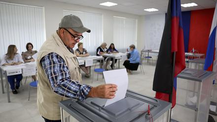 Ein Mann wirft seinen Stimmzettel in eine Wahlurne während der Regionalwahlen in Donezk, der Hauptstadt der russisch kontrollierten Region Donezk. Bei den bis Sonntag angesetzten Regionalwahlen in Russland hatten unabhängige Beobachter vielerorts Verstöße und Betrug gemeldet. 
