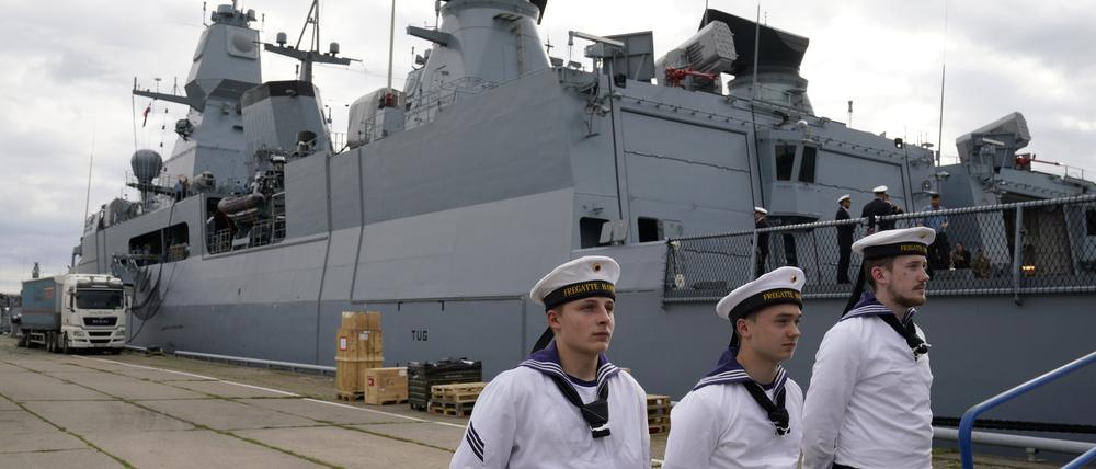 Besatzungsmitglieder der deutschen Fregatte Hamburg stehen vor dem Schiff in Riga.