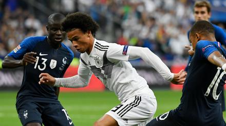 Deutschland gegen Frankreich: Leroy Sane mit N’Golo Kanté und Kylian Mbappe kämpfen bei einem Länderspiel 2018 um den Ball. 