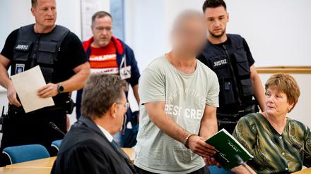 Der mutmaßliche Brandstifter von Apolda wird von Justizbeamten in den Sitzungssaal geführt. Der Bulgare soll Ende August vergangenen Jahres mit zwei gefüllten Benzinkanistern ein Mehrfamilienhaus in Apolda in Brand gesetzt haben. Dabei starben vier Menschen. 