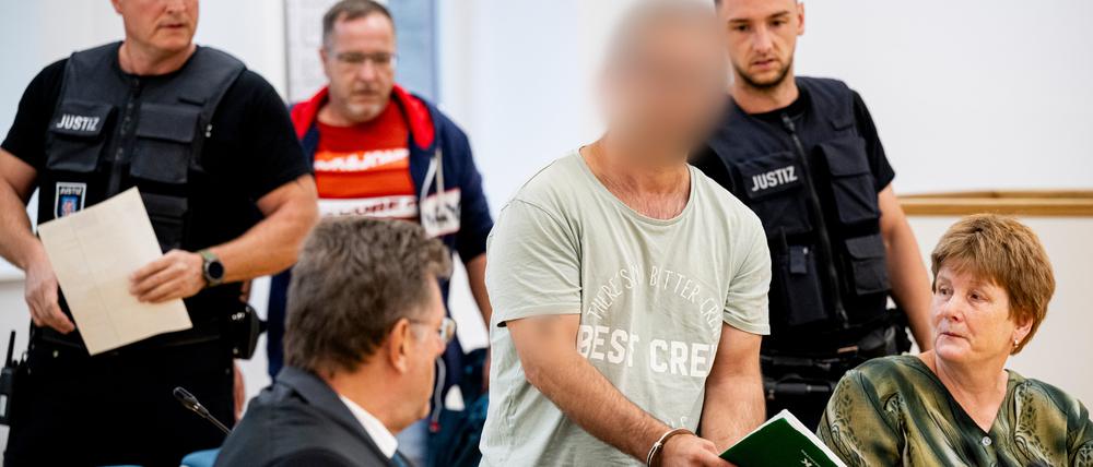 Der mutmaßliche Brandstifter von Apolda wird von Justizbeamten in den Sitzungssaal geführt. Der Bulgare soll Ende August vergangenen Jahres mit zwei gefüllten Benzinkanistern ein Mehrfamilienhaus in Apolda in Brand gesetzt haben. Dabei starben vier Menschen.