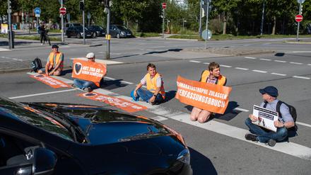  Klimaaktivisten der ·Letzten Generation· bilden in München eine Straßenblockade. 