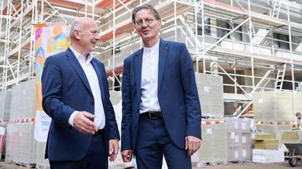 Kai Wegner (l, CDU), Regierender Bürgermeister Berlin und Christian Gaebler (l-r, SPD), Senator für Stadtentwicklung, Bauen und Wohnen stehen auf einer Baustelle eines Neubauprojekts der Degewo am Halleschen Ufer. Auf der Neubautour werden vier Neubauprojekte von landeseigenen Wohnungsbaugesellschaften besichtigt.