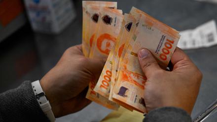 Ein Mann zählt 1000-Pesos-Scheine.