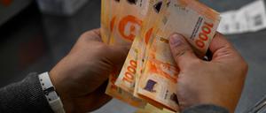 Ein Mann zählt 1000-Pesos-Scheine.