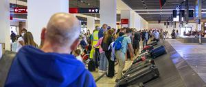 Symbolbild Flughafen Deutschland, Berlin, BER Flughafen am 03.09.2021: Rückreisende warten auf ihr Gepäck. Auf dem Gepäckband sind viele Koffer. *** Symbolic image airport Germany, Berlin, BER airport on 03 09 2021 Returning passengers wait for their luggage On the baggage carousel are many suitcases 